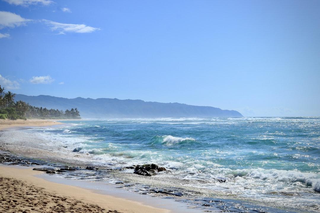 a sandy beach with waves coming in to shore