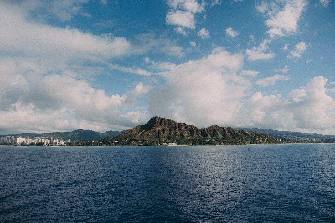 a body of water with a hill in the background